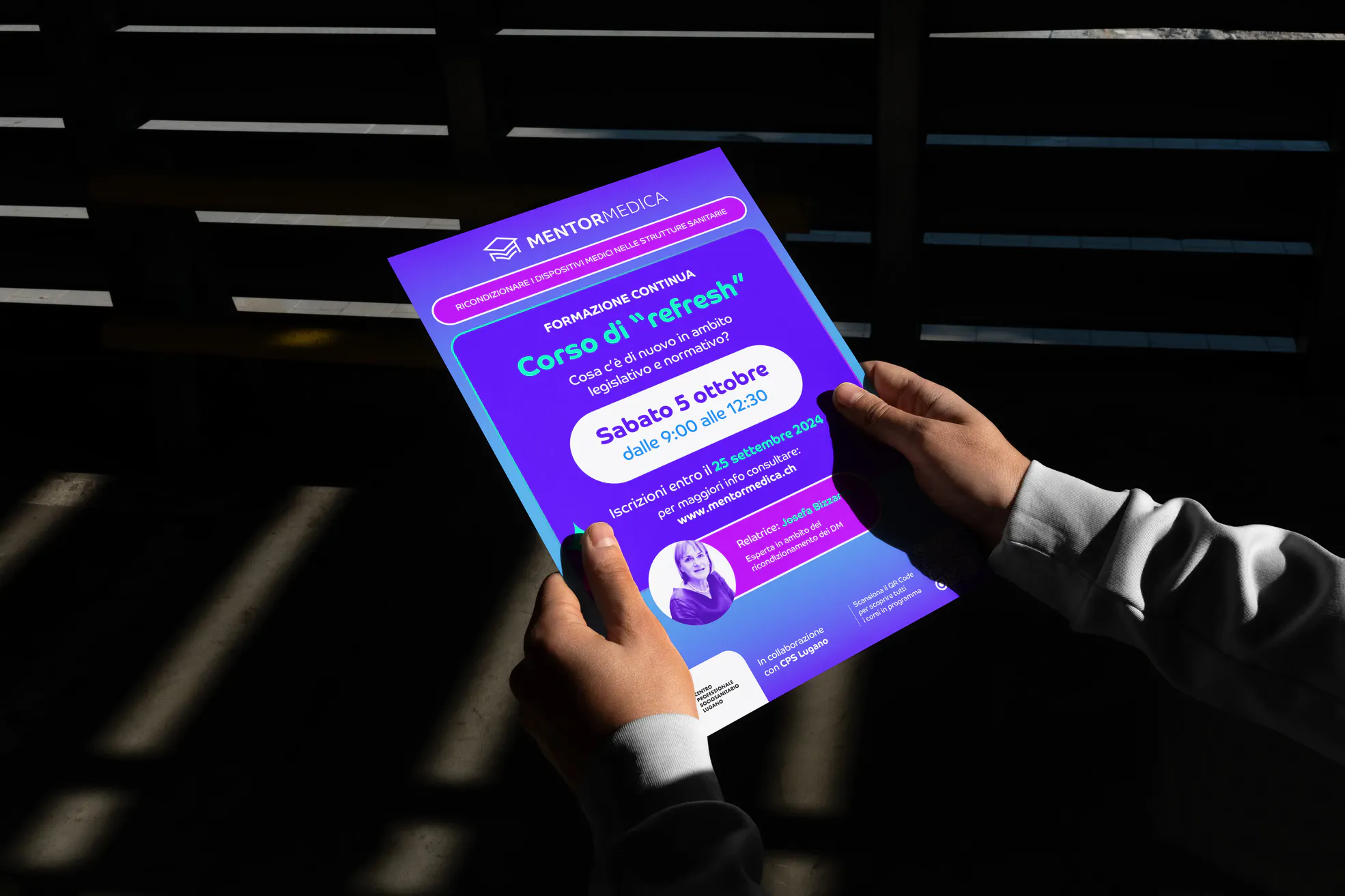 Due mani reggono un poster di Mentor Medica per un corso di formazione sanitaria